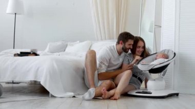 Modern bir genç Aile kavramı. Veliler bir beyaz iç uyumak için özel bir cihaz uyku onların bebeğe göz kulak ol