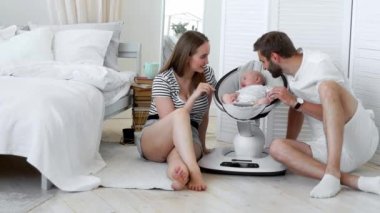 Kapat - yukarıya-in onların küçük bebek beyaz bir daire içinde sallanan bir bebek koltuğu evde uyku izlerken mutlu anne. Minimalizm kavramı