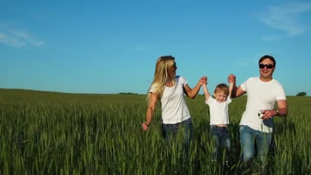 Familia feliz: Padre, madre e hijo, corriendo en el campo vestidos con camisetas blancas — Vídeos de Stock