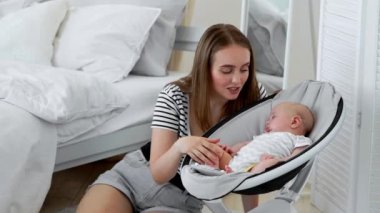 Beyaz yatak odasında online alışveriş yapan izinli bebeğin yanında uyuyan hamile iken,