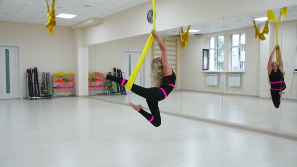 Sağlıklı yaşam için spor kavramı. Kız aerology antigravity rahatlatır ve bir beyaz odada tuval üzerinde salıncak oldu. Üzerine yağlıboya kendi ekseni çevresinde döndürme — Stok video