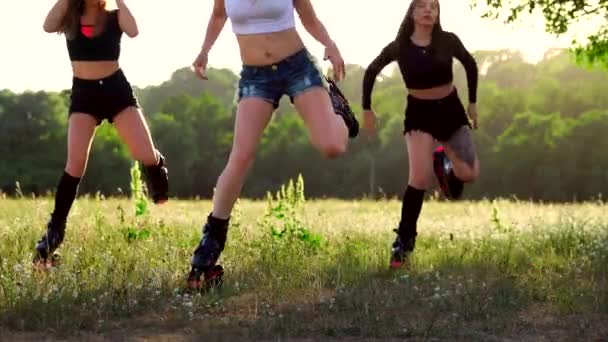 Treino em grupo kangoo. Três meninas ao pôr do sol no parque fazendo fitness — Vídeo de Stock