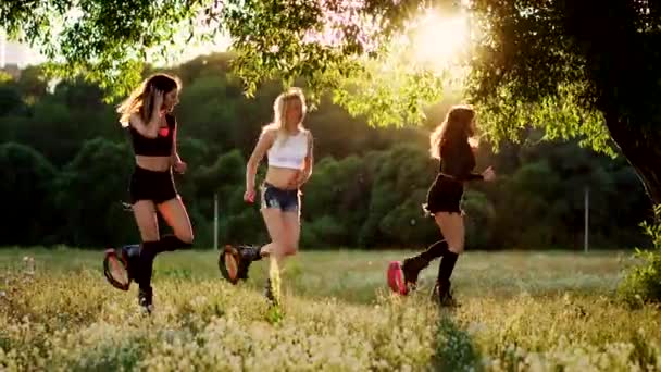 Treino em grupo kangoo. Três meninas ao pôr do sol realizar exercícios dinâmicos destinados à perda de peso e fortalecimento muscular — Vídeo de Stock