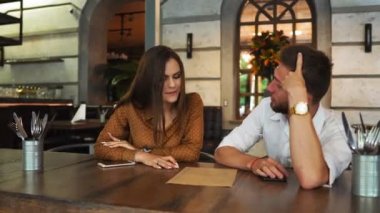 Güzel bir çift birlikte bir restoranda oturuyorsun. O çay içme ve onun biyfriend onlar için yiyecek almaya çalışıyor iken menüye arıyorum. Ayrıca ona için gıda tavsiyeleri veriyor.