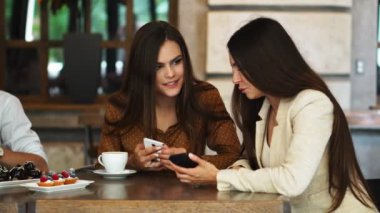 İki kız seyir telefon bir kafede oturan ve gördüklerini tartışmak. Bir adam çıkageldi ve resmi bir komik onun teelphone gösterir.