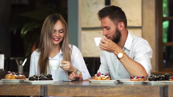 Mutlu çift medya içeriği satırındaki herkes bir kafede onun akıllı telefon ile paylaşımı — Stok video