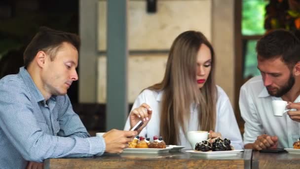 Multi-etnische groep jonge vrienden praten en het gebruik van smartphones apps op wifi in het café, gelukkige duizendjarige mensen plezier met telefoons delen koffie huis tabel genieten van vergadering in openbare ruimte — Stockvideo