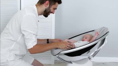 Modern beşiğinde yatan bebek ile babası çalış. Modern tarzda kavramı.