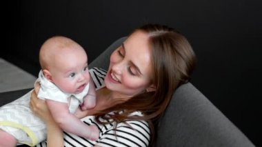Anne ve bebek koyu arka koltukta oturup sohbet
