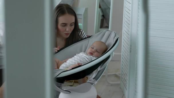 En la habitación blanca dedicada a las compras en línea mientras está de baja por maternidad, durmiendo al lado del bebé — Vídeos de Stock