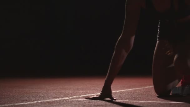 Drei Sportlerinnen starten nachts auf dem Laufband auf der Sprintdistanz von der Sitzposition aus ins Rennen — Stockvideo