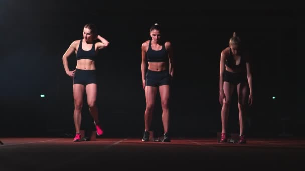 Drie meisjes in zwarte kleding zijn in de startende pads om te beginnen de wedstrijd in de competitie. — Stockvideo