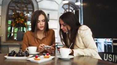 Bir grup büyük tablo ve gösteri bir kafede otururken office giysili kadın ve erkek her diğer içinde hareket eden komik resimler telefonları.