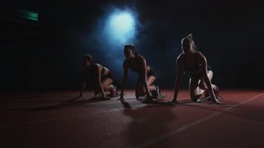 Atletizm, kadın koşucu bir yarıştan önce başlayan blok, çömelme izlemek. Ağır çekimde.