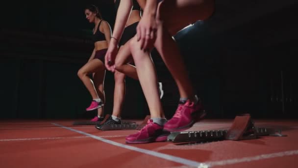 Atletizm, kadın koşucu bir yarıştan önce başlayan blok, çömelme izlemek. Ağır çekimde. — Stok video