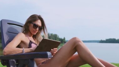 Tatilde ince bir genç esmer bir mayo sosyal ağlar fotoğraflarını yayınlar.