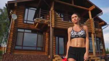 Seksi esmer siyah üst ve bir egzersiz ıslak gidince şort yakınındaki büyük konak ve İçecek suyu şişe