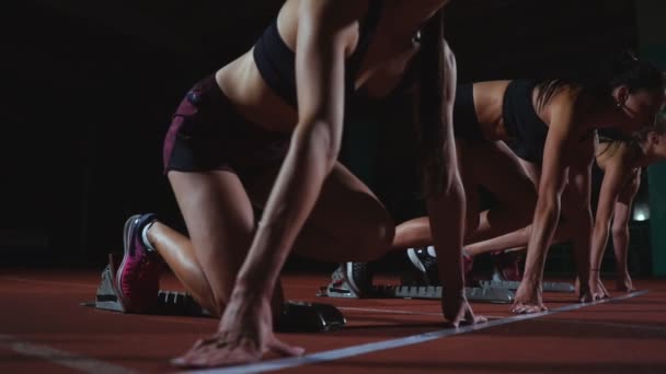 Kvinnliga idrottare värmer upp på löparbana innan ett lopp. I slow motion — Stockvideo