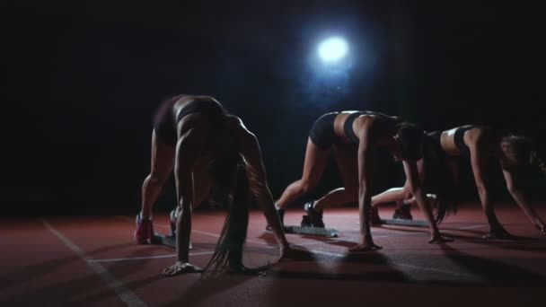 Las atletas femeninas se calientan en la pista antes de una carrera. En cámara lenta — Vídeo de stock