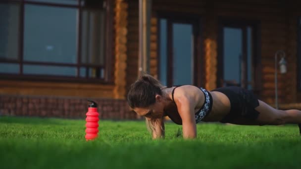 Chica en forma haciendo ejercicio de tablón al aire libre en el parque cálido día de verano. Concepto de resistencia y motivación — Vídeo de stock