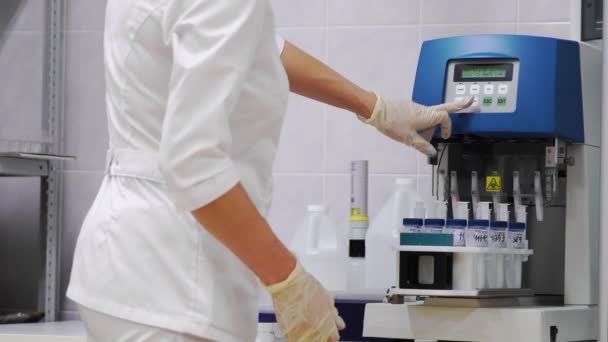 Dziewczyna ustawia próbki damskie ginekologiczne płynu do analizy na raka, zautomatyzowanych badań — Wideo stockowe