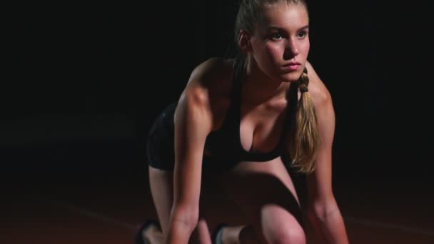 Vrouwelijke atleet op een donkere achtergrond is voorbereiding op het uitvoeren van de cross-country sprint van de pads op de loopband op een donkere achtergrond — Stockvideo