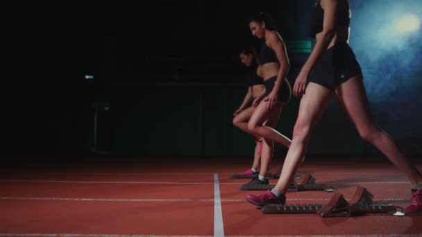Жінки-спортсмени розігріваються на біговій доріжці перед гонкою. У повільному русі — стокове відео