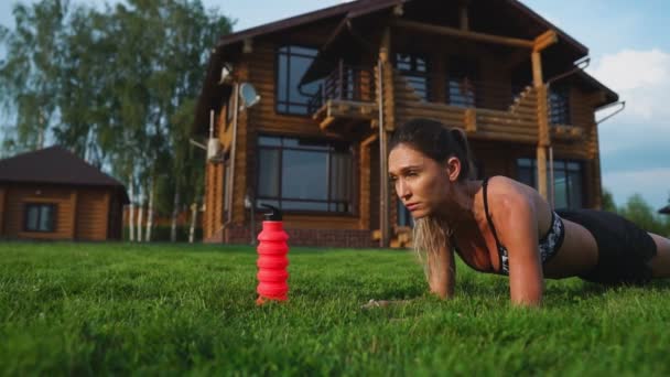 夏の暖かい日に公園の屋外で板運動をするフィットの女の子 持久力とやる気の概念 — ストック動画