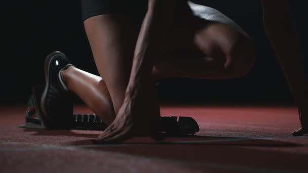 Atleta femenina sobre un fondo oscuro para correr el sprint de la almohadilla de cross country en la cinta sobre un fondo oscuro — Vídeos de Stock