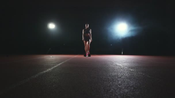 Sportlerin auf dunklem Hintergrund, um auf dem Laufband vor dunklem Hintergrund den Sprint des Langlaufpolsters zu laufen — Stockvideo