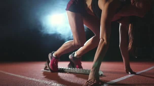 Sportlerin auf dunklem Hintergrund bereitet sich auf den Langlauf-Sprint von den Polstern auf dem Laufband auf dunklem Hintergrund vor — Stockvideo