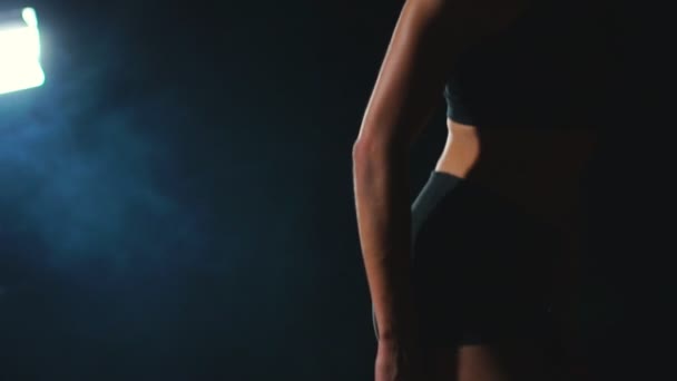 Молодая спортсменка в черных шортах и футболке готовится стартовать в забеге на 100 метров на беговой дорожке возле стартовой линии — стоковое видео