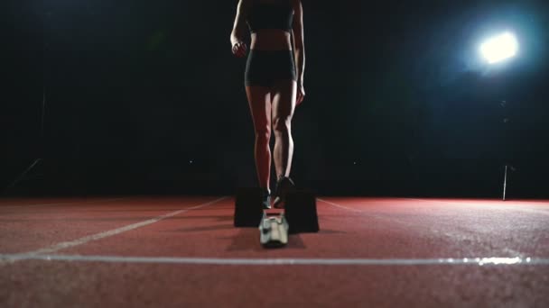 Las piernas de primer plano del atleta se acercan a la cinta de correr y se ponen en posición para comenzar la carrera — Vídeos de Stock