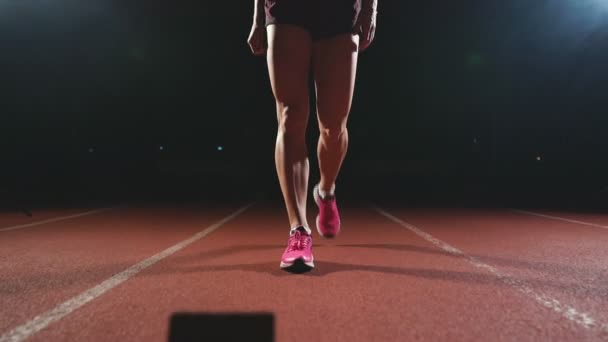Крупним планом ноги спортсмена підходять до бігової доріжки і стають на позицію, щоб почати гонку — стокове відео
