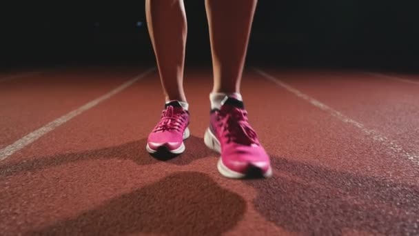 Patas de primer plano en zapatillas de deporte atletas son almohadillas para correr en la pista del complejo deportivo y correr en cámara lenta — Vídeo de stock