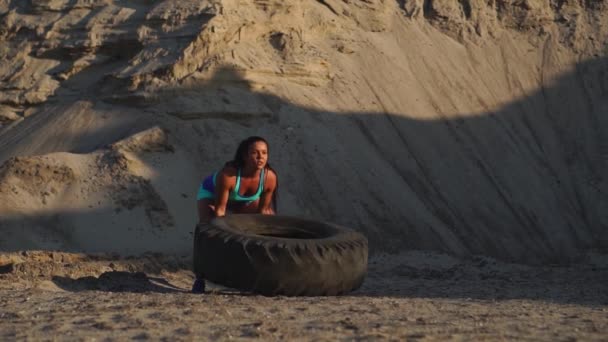 Una chica en ropa deportiva tiene un neumático. Entrenamiento callejero . — Vídeo de stock