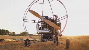 Motorlu yamaçparaşütü alanını günbatımında tahta bir pervane ile standları ve pilot paraşüt uzanır ve askılar hizalar. Uçuş hazırlığı
