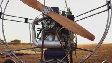 Motorlu yamaçparaşütü alanını günbatımında tahta bir pervane ile standları ve pilot paraşüt uzanır ve askılar hizalar. Uçuş hazırlığı