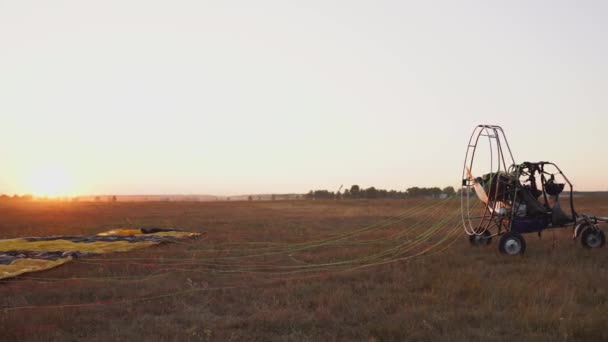 Parapente motor pronto para voar no céu contra o pôr-do-sol em luz solar quente . — Vídeo de Stock