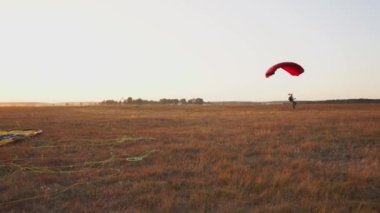 Paraşütçü alanında diğer paraşütçüler arka plan üzerinde uçaktan disembarking sonra toprakları