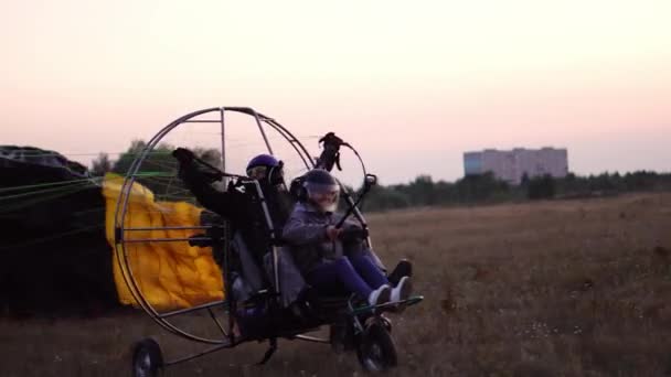 Egy lány és egy férfi a repülőtéren, gyorsul, és levette az égbe, az ejtőernyő leveszi motoros Siklóernyő — Stock videók