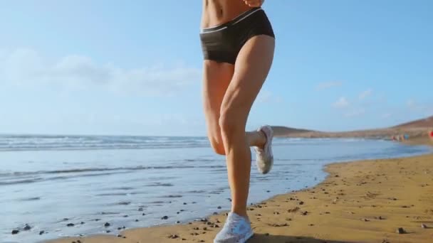 Mulher atleta silhueta correndo na praia ondas sprint bater à beira-mar manhã fundo câmera lenta — Vídeo de Stock