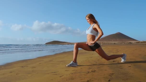 瑜伽务虚会和训练-妇女在瑜伽姿势在海滩在日出。女性瑜伽女孩在宁静的海洋景观锻炼训练。慢动作斯坦尼康 — 图库视频影像