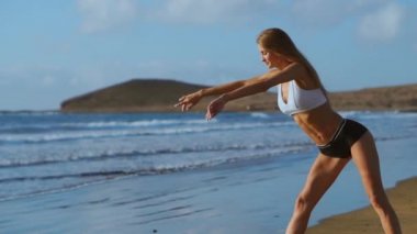 Kadın germe bacaklar ve ileri ayakta Bend Yoga streç yapmak hamstrings sahilde poz. Rahatlatıcı ve üzerinde spor ve yoga pratik fitness kadın.