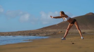 Kadın germe bacaklar ve ileri ayakta Bend Yoga streç yapmak hamstrings sahilde poz. Rahatlatıcı ve üzerinde spor ve yoga pratik fitness kadın.