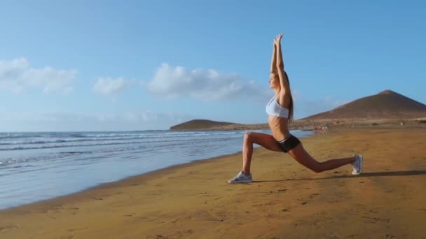Жінка розтягує ноги і хустки, роблячи Стоячи вперед Бенд Йога розтягує позу на пляжі. Фітнес жінка розслабляє і практикує спорт і йогу на . — стокове відео