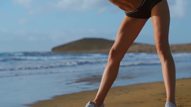 Mulher esticando pernas e isquiotibiais fazendo de pé para a frente dobrar Yoga esticar pose na praia. Fitness mulher relaxando e praticando esporte e ioga em . — Vídeo de Stock