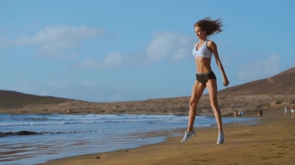Sportswoman이 라오 야외에서 운동을 하 고 운동복을 입고입니다. 피트 니스 여성 일몰 해변에 밖으로 작동. 운동 젊은 여자 야외 스포츠에 종사 하는. — 비디오