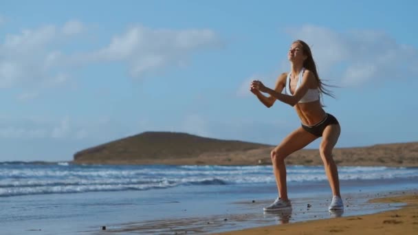 Дівчина робить ногу тренування на пляжі. СЛАДНІЙ СКАДІКАМ — стокове відео