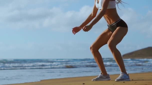 Menina fazendo perna de treino na praia. SLOW MOTION STEADICAM — Vídeo de Stock